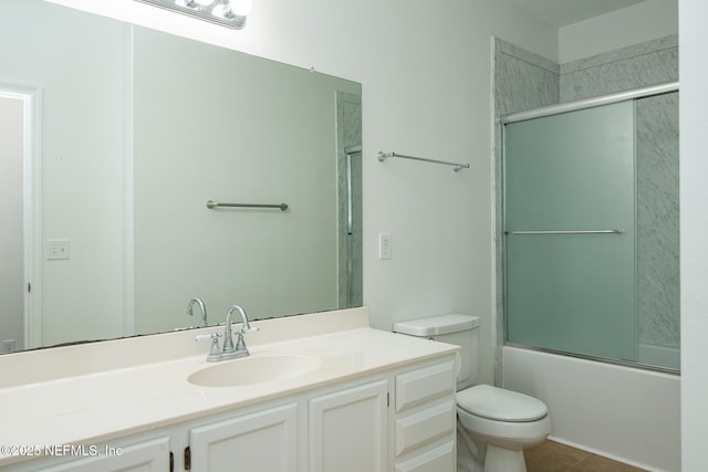 full bathroom with enclosed tub / shower combo, vanity, and toilet