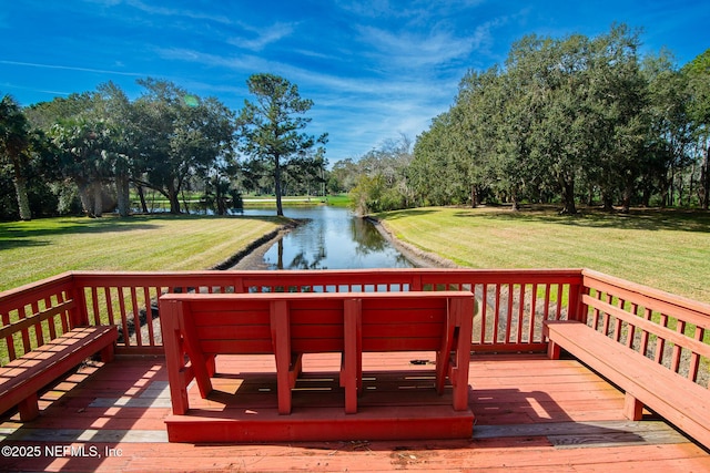 wooden terrace with a water view and a yard