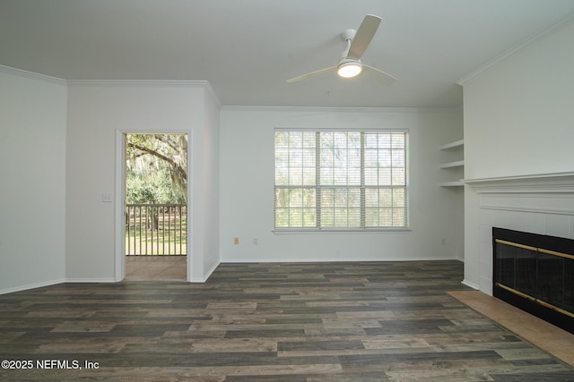 unfurnished living room featuring crown molding, a tile fireplace, dark hardwood / wood-style floors, and ceiling fan