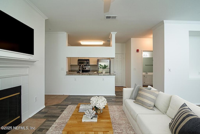 140 Veracruz Dr Unit 627, Ponte Vedra Beach, FL 32082 - living area featuring visible vents, ornamental molding, dark wood-type flooring, a tile fireplace, and a ceiling fan
