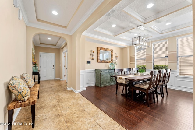 dining area with crown molding, coffered ceiling, a chandelier, and light wood-type flooring