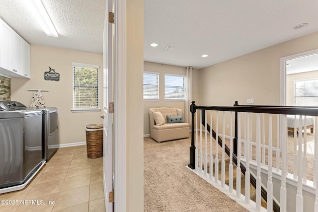 clothes washing area with cabinets, separate washer and dryer, and a wealth of natural light