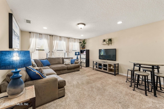 living room featuring light carpet and a textured ceiling