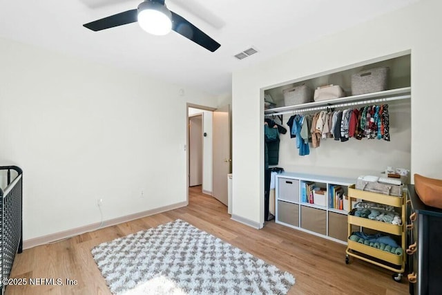 bedroom featuring wood-type flooring, ceiling fan, and a closet