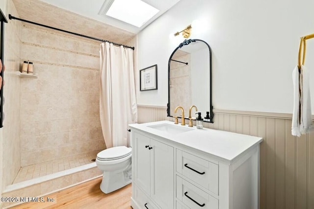 bathroom with hardwood / wood-style flooring, vanity, curtained shower, and toilet