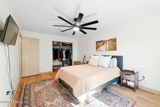 bedroom featuring wood-type flooring, ceiling fan, and a closet