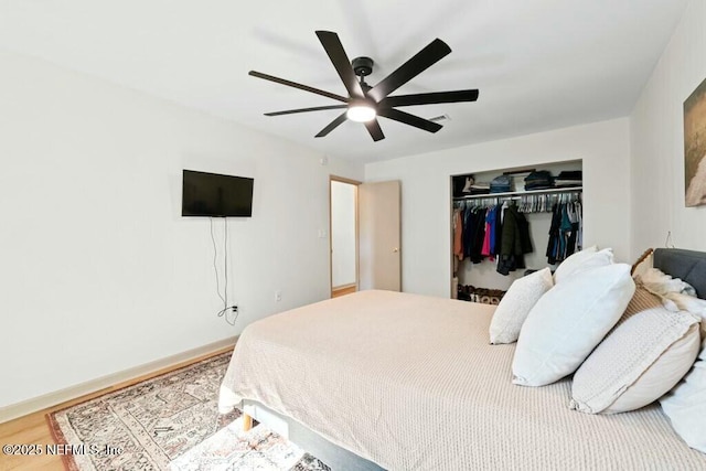 bedroom with ceiling fan, wood-type flooring, and a closet