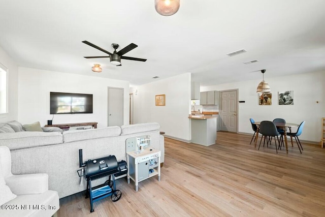 living room featuring ceiling fan and light wood-type flooring