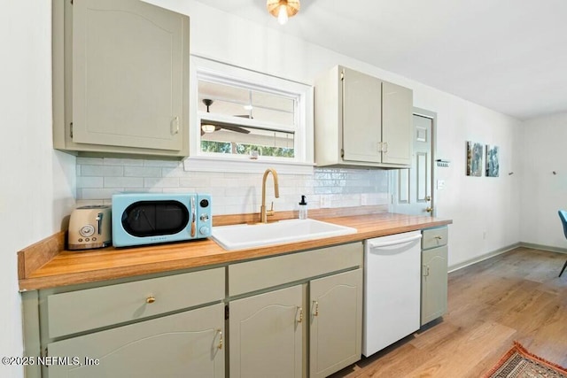 kitchen with tasteful backsplash, white dishwasher, light hardwood / wood-style floors, and sink