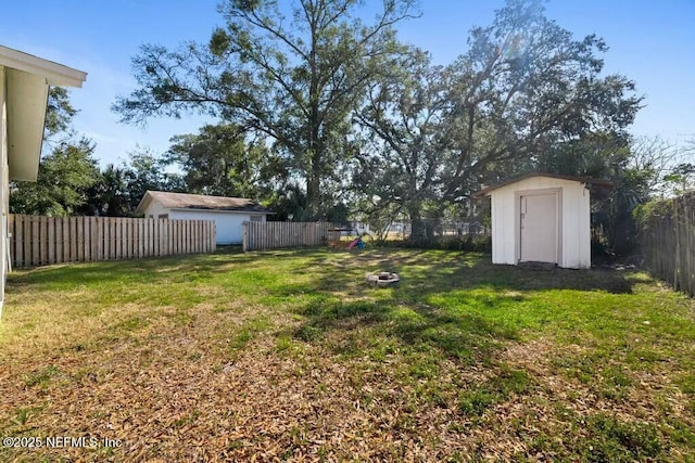 view of yard with a fire pit and a shed