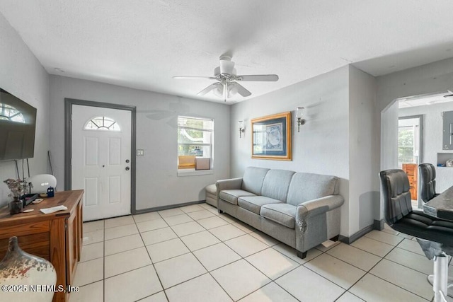 living room featuring light tile patterned flooring, ceiling fan, electric panel, and a textured ceiling