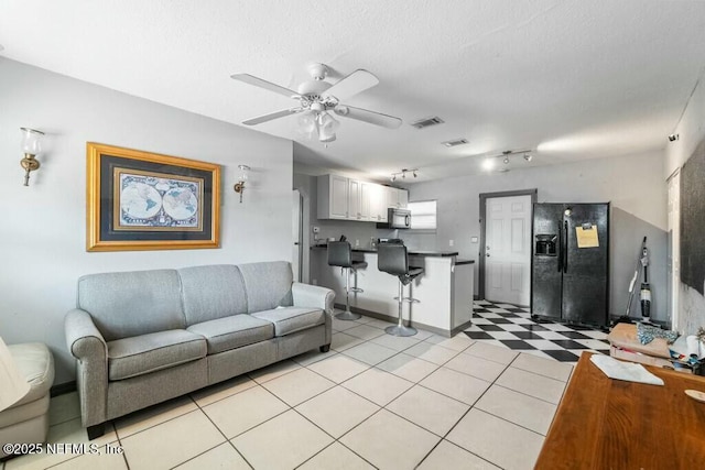 living room with a textured ceiling, rail lighting, and ceiling fan