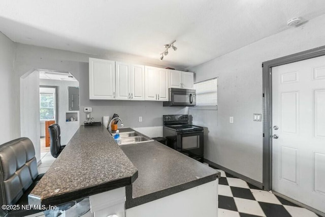 kitchen with black appliances, rail lighting, sink, white cabinets, and kitchen peninsula