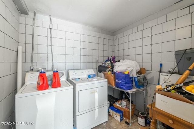 laundry area with tile walls and washing machine and dryer