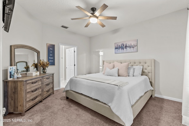 bedroom featuring light carpet, ensuite bath, and ceiling fan