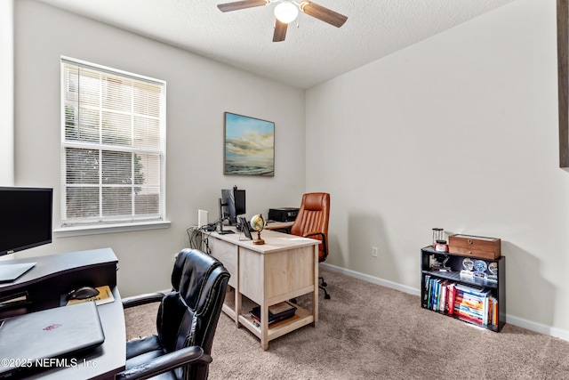 home office with a textured ceiling, ceiling fan, and carpet flooring