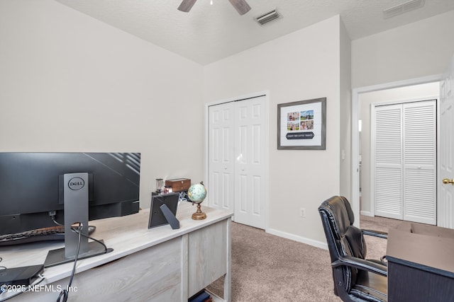 carpeted office featuring a textured ceiling and ceiling fan