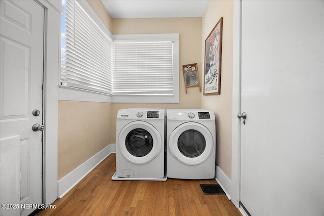 laundry room featuring separate washer and dryer and light hardwood / wood-style flooring