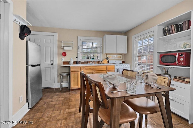 dining space featuring dark parquet flooring and sink