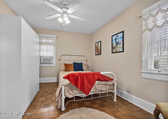 bedroom featuring multiple windows, cooling unit, dark parquet floors, and ceiling fan