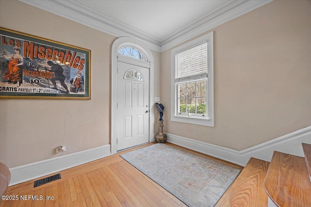 foyer entrance with hardwood / wood-style flooring and ornamental molding