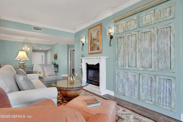 living room featuring crown molding, a high end fireplace, and hardwood / wood-style flooring