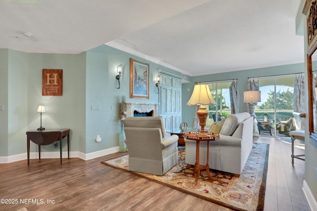 living room featuring ornamental molding, a fireplace, and hardwood / wood-style floors