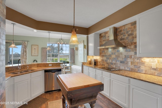 kitchen featuring wall chimney exhaust hood, sink, white cabinetry, hanging light fixtures, and stainless steel dishwasher