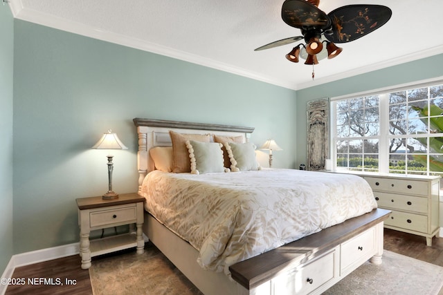 bedroom featuring crown molding, dark wood-type flooring, and ceiling fan