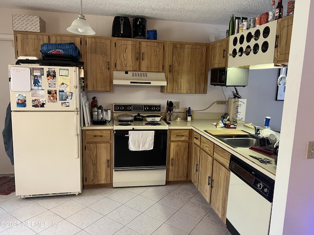 kitchen with white appliances, decorative light fixtures, sink, and a textured ceiling