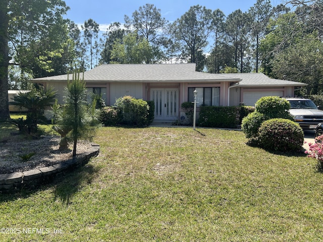 ranch-style home featuring a garage, french doors, and a front lawn