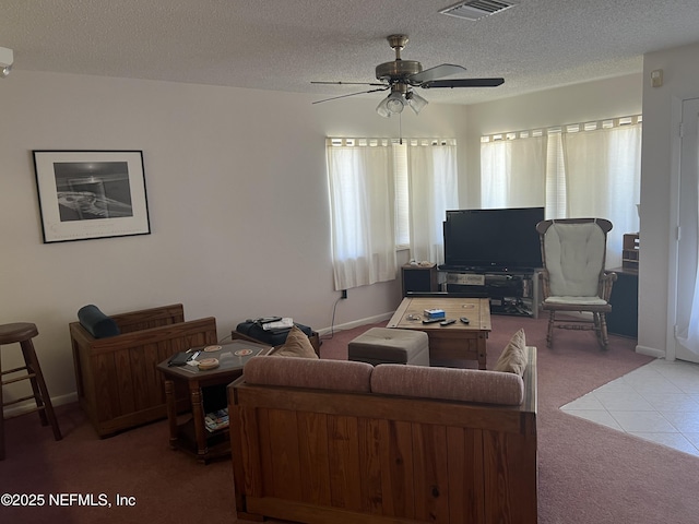 living room with ceiling fan, carpet floors, and a textured ceiling