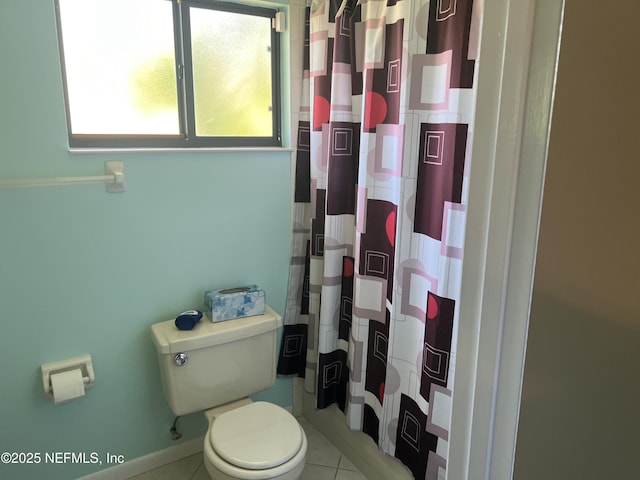 bathroom featuring a shower with shower curtain, toilet, and tile patterned flooring