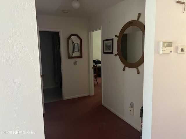 corridor with dark colored carpet