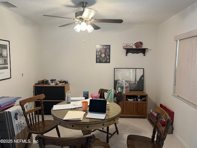 tiled dining space featuring ceiling fan and a textured ceiling