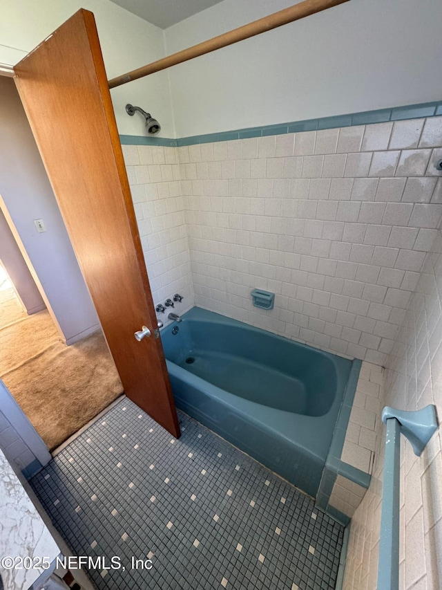 bathroom with tile patterned flooring and tiled shower / bath