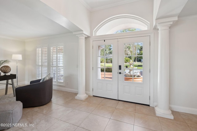 tiled entrance foyer featuring decorative columns, crown molding, and french doors