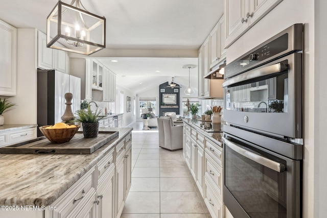 kitchen featuring light stone counters, decorative light fixtures, white cabinets, and appliances with stainless steel finishes