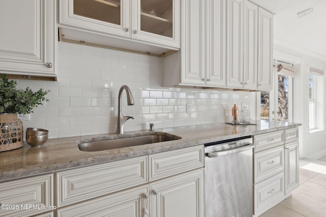 kitchen featuring white cabinetry, dishwasher, sink, and light stone counters