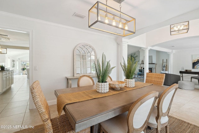 tiled dining space featuring decorative columns and ornamental molding