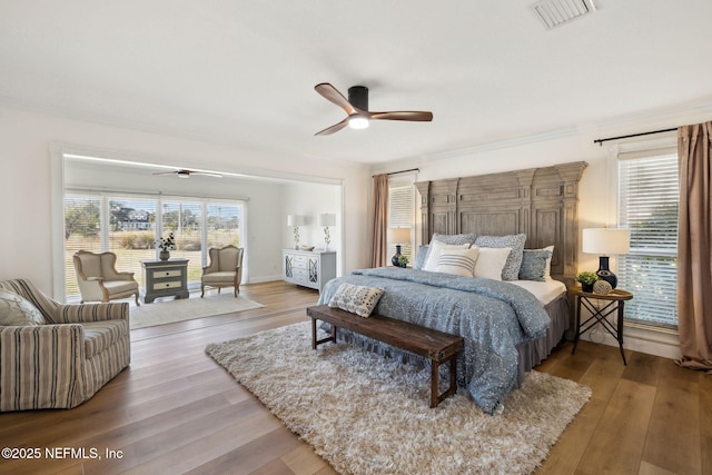 bedroom with multiple windows, wood-type flooring, ceiling fan, and access to outside