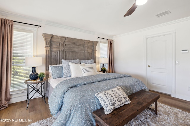 bedroom featuring hardwood / wood-style flooring, ornamental molding, and ceiling fan