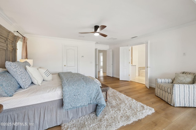 bedroom featuring ceiling fan, ornamental molding, hardwood / wood-style floors, and ensuite bath