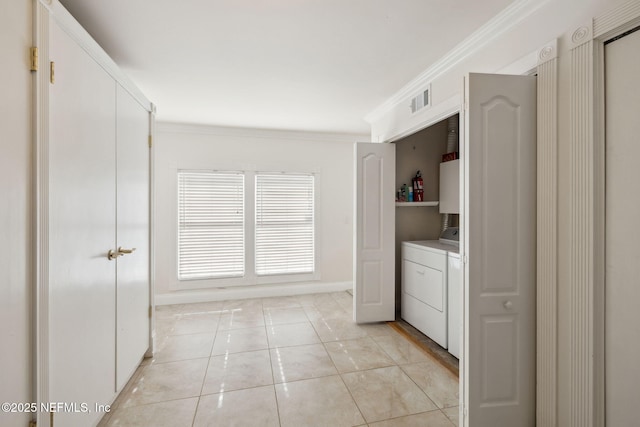 laundry area featuring crown molding, separate washer and dryer, and light tile patterned floors