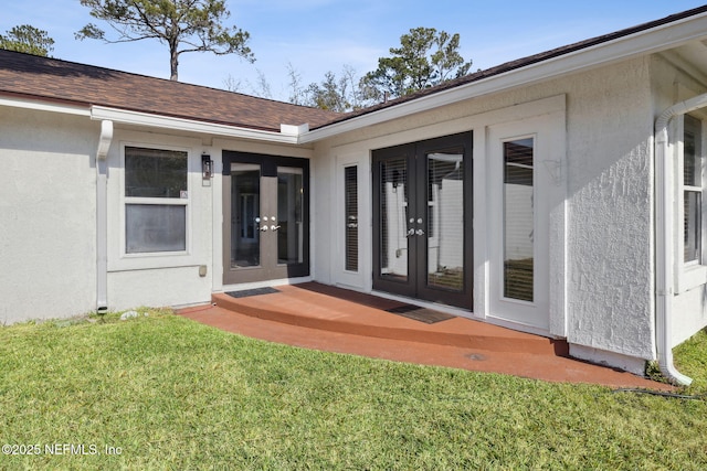 doorway to property featuring a lawn and french doors