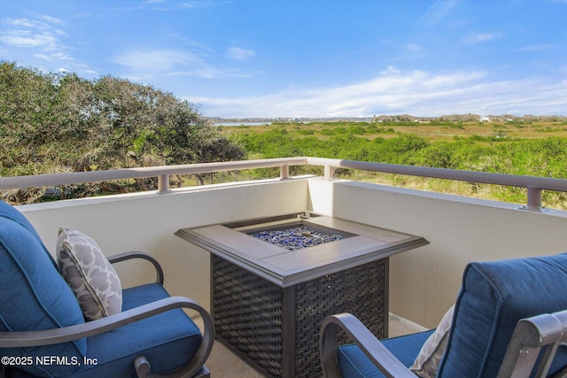 balcony featuring an outdoor fire pit and a rural view