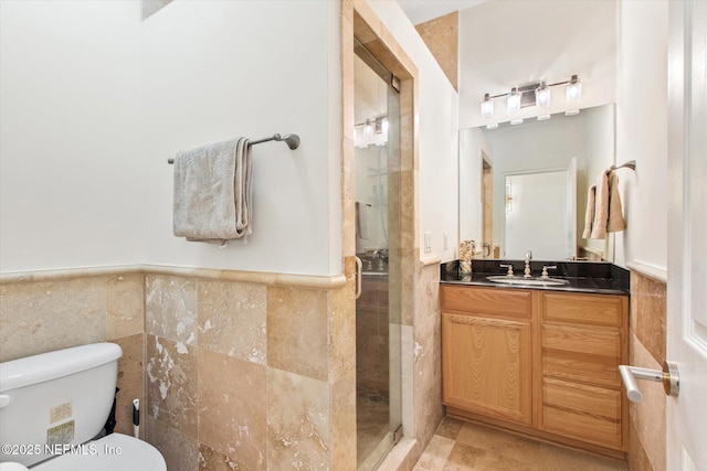 bathroom featuring tile walls, vanity, toilet, and walk in shower