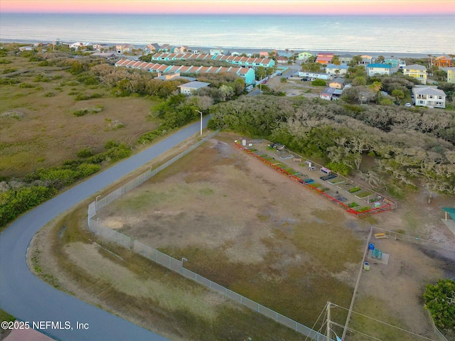 aerial view at dusk featuring a water view