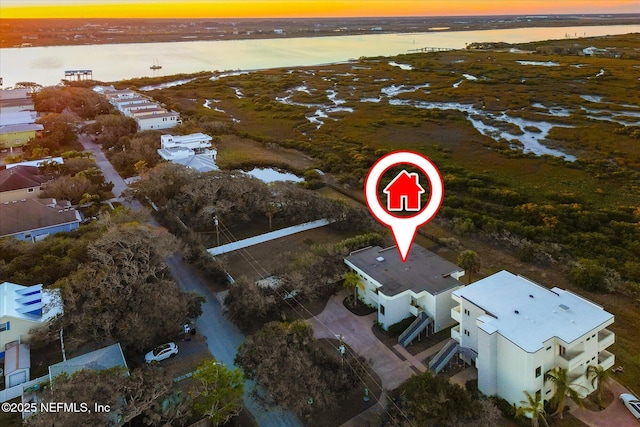 aerial view at dusk featuring a water view