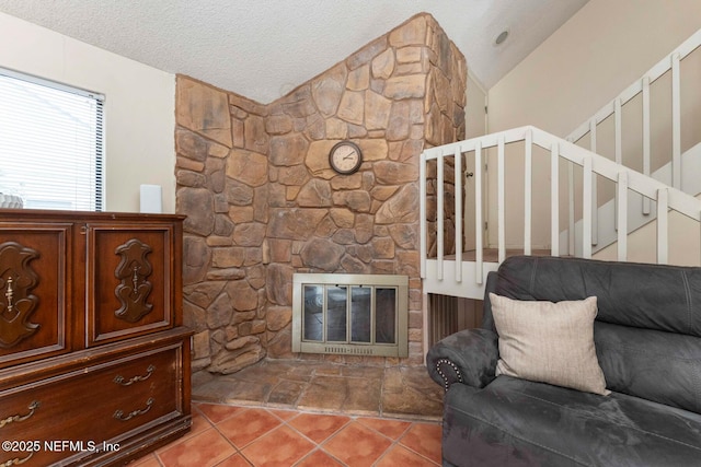 living room featuring a fireplace, light tile patterned floors, lofted ceiling, a textured ceiling, and stairs